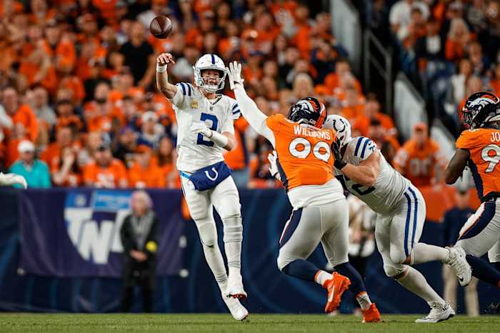 Indianapolis Colts quarterback Matt Ryan (2) passes under pressure from Denver Broncos defensive tackle DeShawn Williams (99) as offensive tackle Braden Smith (72) defends in the first quarter at Empower Field at Mile High.